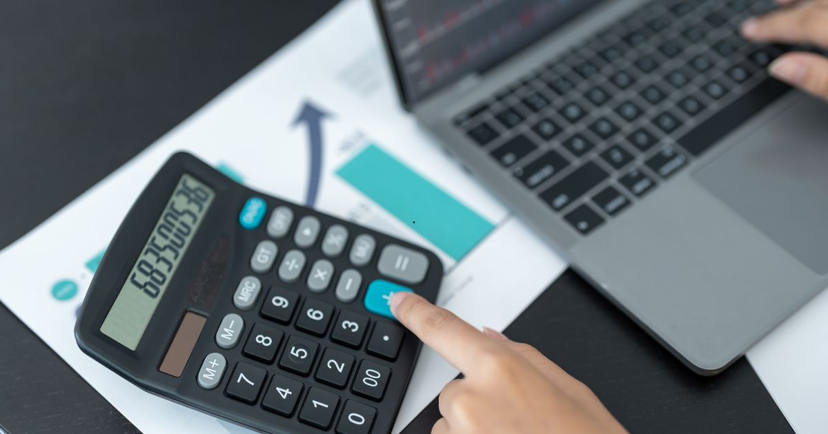 man using calculator and laptop man using calculator and laptop