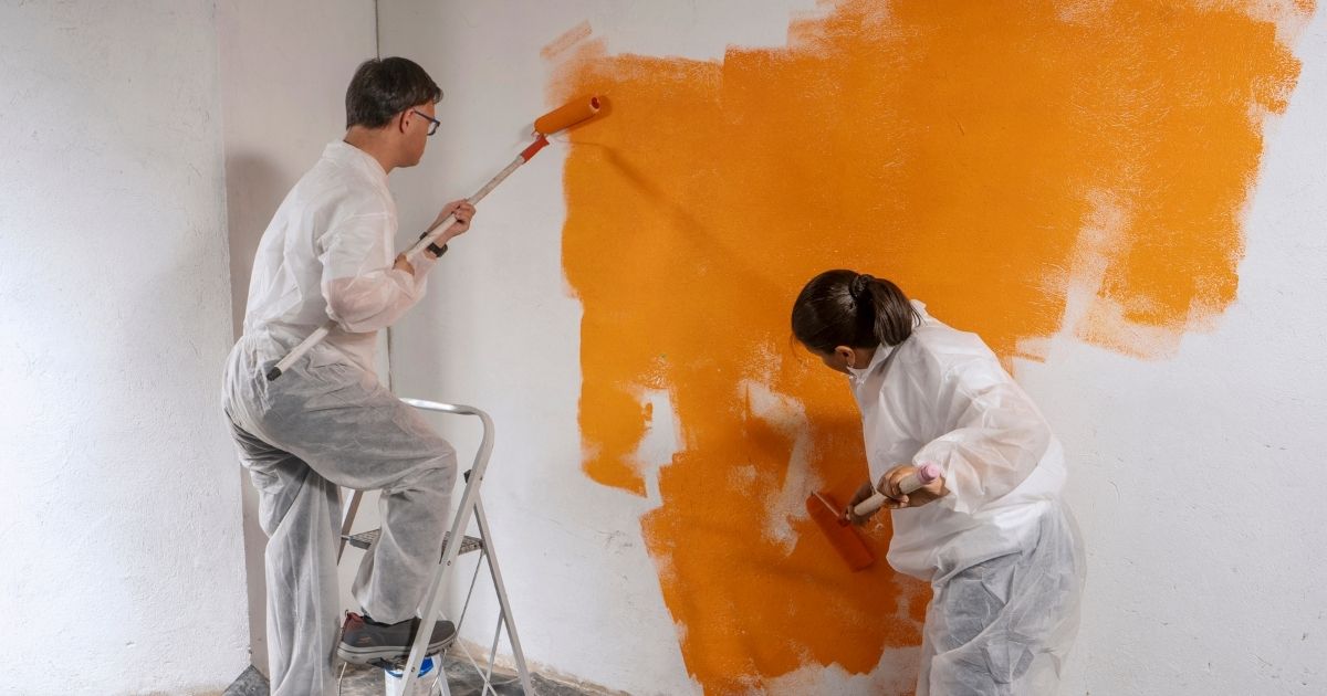 people painting orange wall