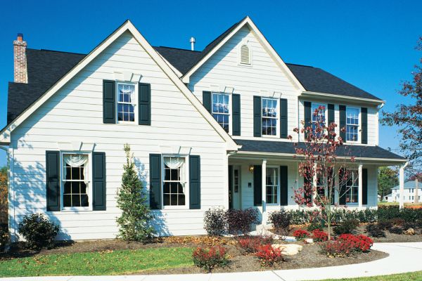Freshly painted two-story home with white siding, dark shutters, and well-maintained landscaping under a clear blue sky. Freshly painted two-story home with white siding, dark shutters, and well-maintained landscaping under a clear blue sky.