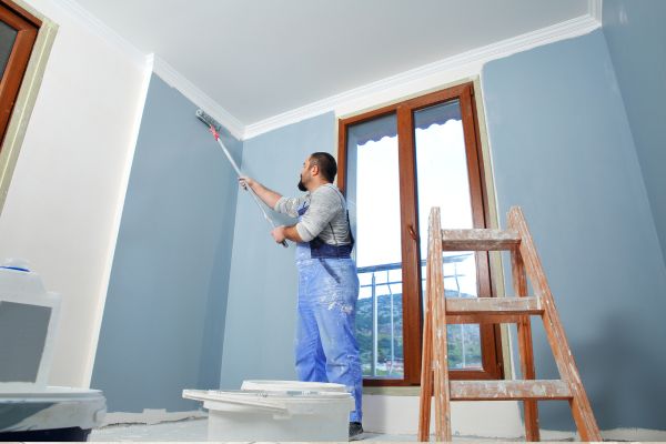 man painting the wall in blue